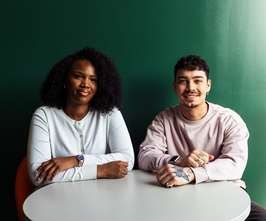 Students walking together through a leafy campus pathway in autumn.